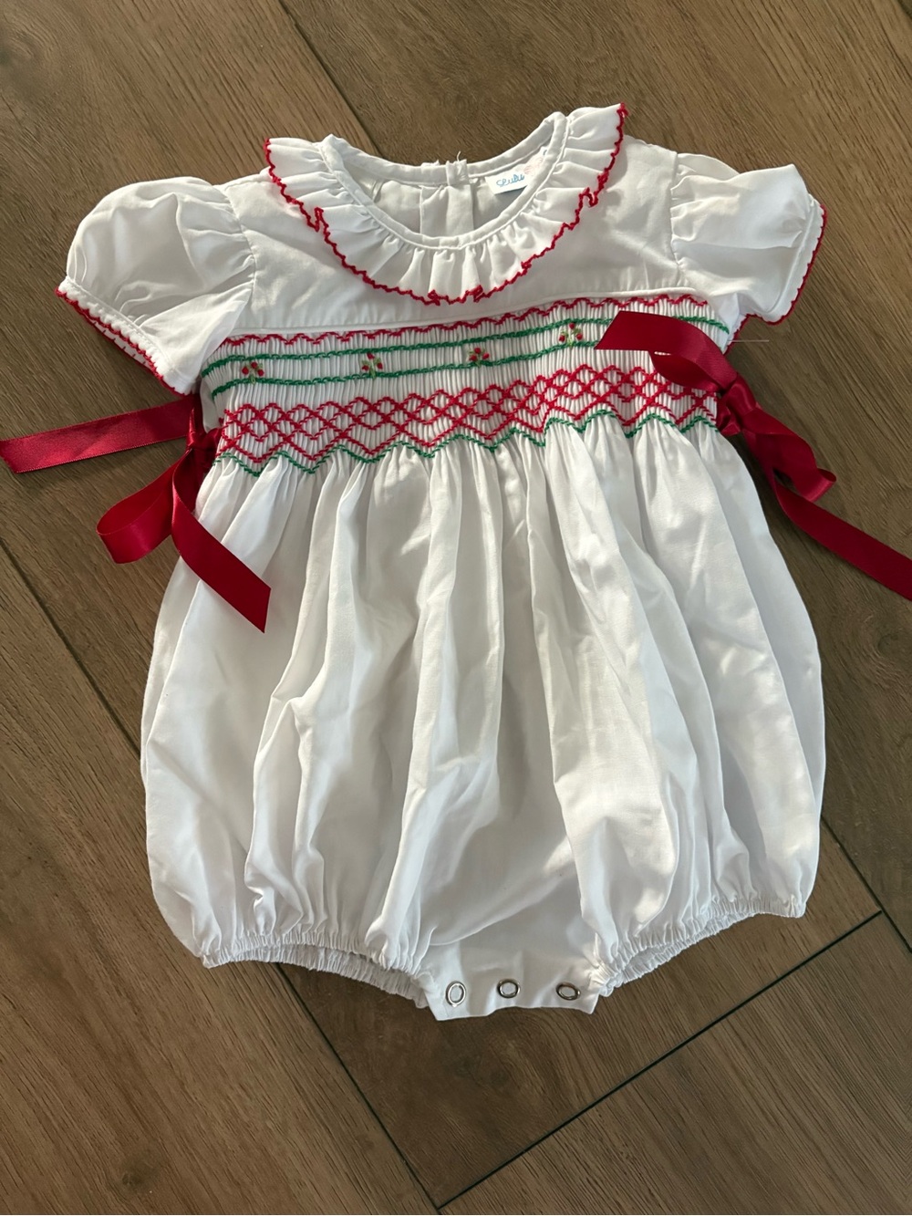 White Smocked Baby One-Piece with Red Trim and Ribbon